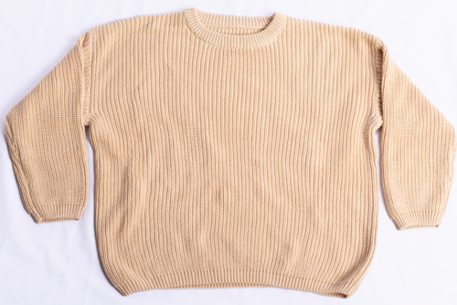 A beige ribbed knit crewneck sweater laid flat on a white background.