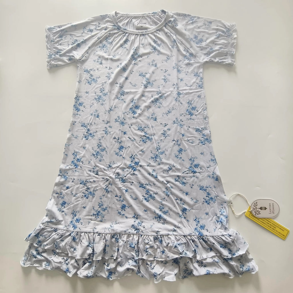 A short-sleeve bamboo nightgown with a blue floral print on a white background, featuring a ruffled hem and a gathered neckline.